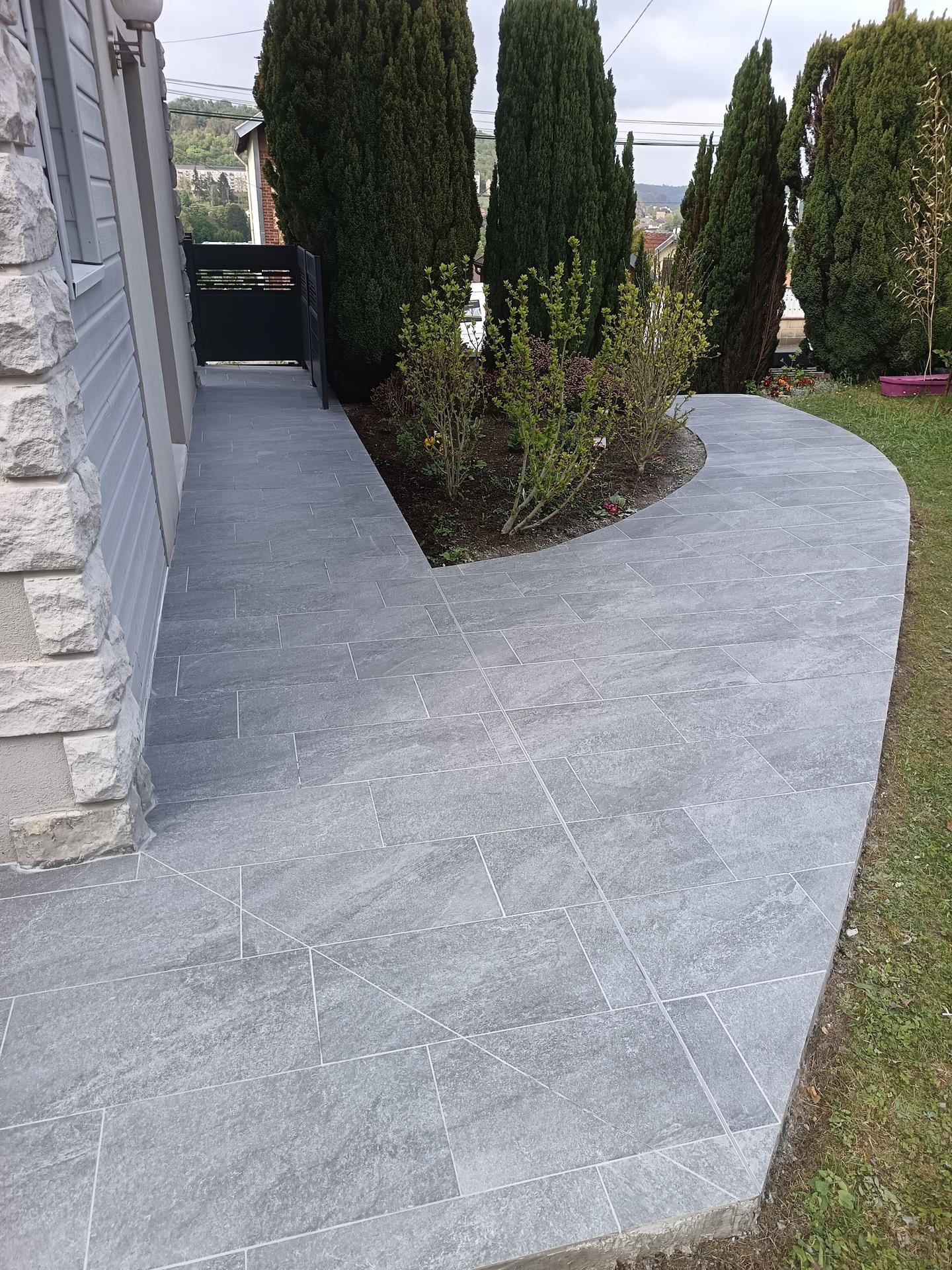 Grande terrasse circulaire en pierre devant une maison contemporaine, réalisée par FG Carrelage Maçonnerie